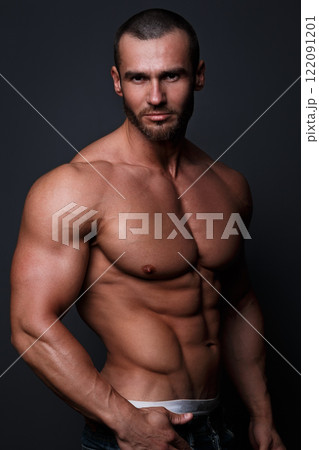 Portrait of handsome muscular man posing in studio 122091201
