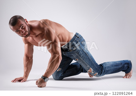 Handsome muscular man wearing jeans posing in studio 122091264