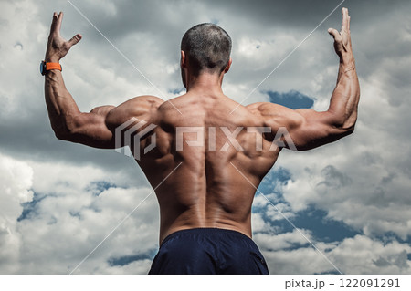 Muscular bearded man posing against cloudy sky 122091291