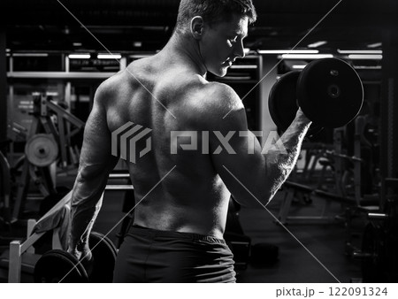 Muscular man with dumbbells in the gym 122091324