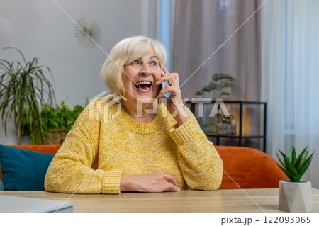 Happy senior old woman involved in pleasant conversation phone call good news enjoy talking gossip 122093065