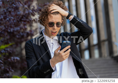 Shocked businessman using smartphone typing browsing, loses surprised by bad news fail bankruptcy Shocked businessman using smartphone typing browsing, loses surprised by bad news fail bankruptcy 122093258