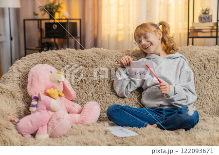 Young teenager girl pretending teacher at home sofa math lesson, toy students, playful serious act 122093671