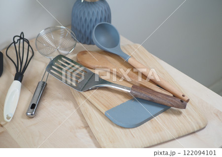 A Variety of Assorted Kitchen Utensils Arranged on a Wooden Cutting Board 122094101