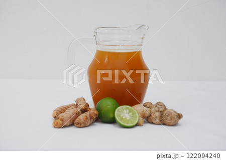 Ginger juice with fresh ginger and lemon on white background. Healthy drink. Ginger juice with fresh ginger and lemon on white background. Healthy drink. 122094240
