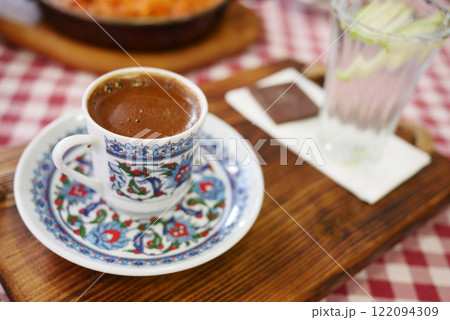 Turkish Coffee in Floral Cup on Checkered Tablecloth 122094309