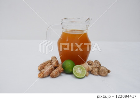 Ginger juice with fresh ginger and lemon on white background. Healthy drink. Ginger juice with fresh ginger and lemon on white background. Healthy drink. 122094417