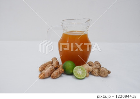 Ginger juice with fresh ginger and lemon on white background. Healthy drink. Ginger juice with fresh ginger and lemon on white background. Healthy drink. 122094418
