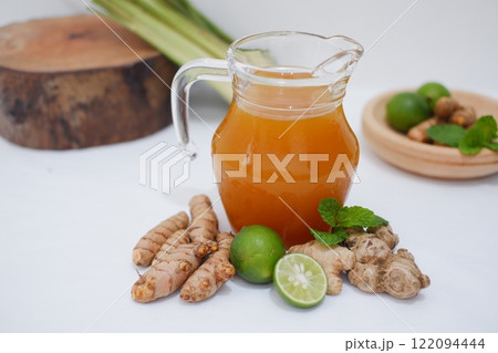 Ginger juice with fresh ginger and lemon on white background. Healthy drink. 122094444