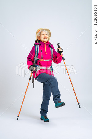 登山装備を身につけて元気に歩くシニア女性 122095158