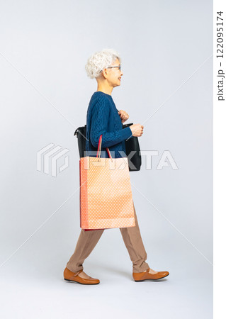 買い物バッグを持って歩くシニア女性の全身写真 買い物バッグを持って歩くシニア女性の全身写真 122095174