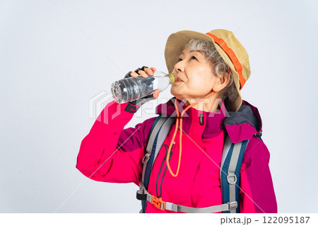 ペットボトルの水を飲む登山服のシニア女性 122095187