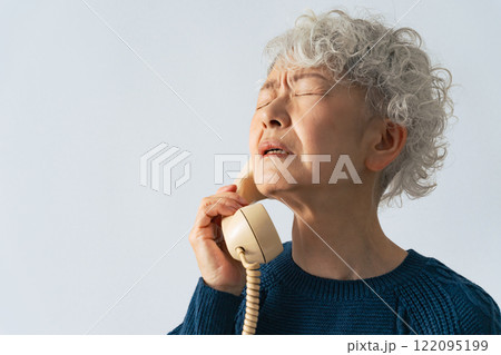 電話しながら落ち込むシニア女性 122095199