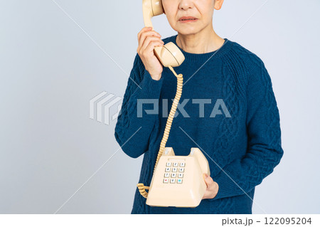 電話しながら落ち込むシニア女性 電話しながら落ち込むシニア女性 122095204