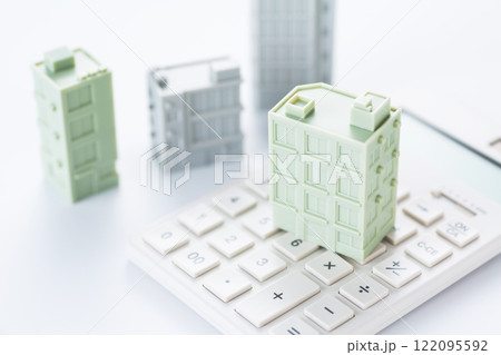 企業ビルの模型と電卓 122095592