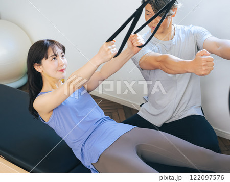 マシンピラティスのレッスンを受ける女性 マシンピラティスのレッスンを受ける女性 122097576