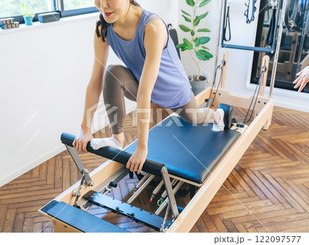 マシンピラティスのトレーニングをする女性 マシンピラティスのトレーニングをする女性 122097577