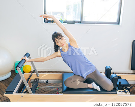 マシンピラティスのトレーニングをする女性 マシンピラティスのトレーニングをする女性 122097578