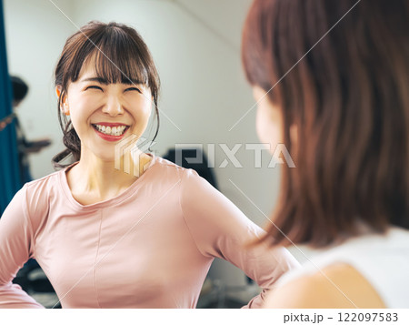 ジムでインストラクターにカウンセリングを受ける女性 122097583