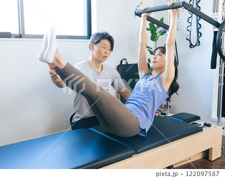 マシンピラティスのトレーニングをする女性 マシンピラティスのトレーニングをする女性 122097587