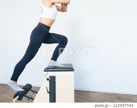 マシンピラティスのトレーニングをする女性 122097593