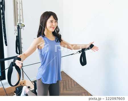 マシンピラティスのトレーニングをする女性 122097603