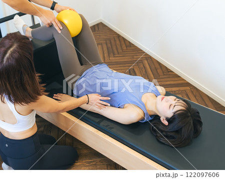 マシンピラティスのレッスンを受ける女性 122097606