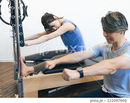 マシンピラティスのレッスンを受ける女性 122097608