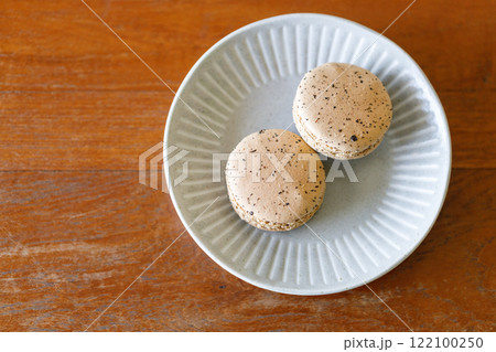 Brown orange Ceylon black tea flavor macaron on wooden table. Brown orange Ceylon black tea flavor macaron on wooden table. 122100250