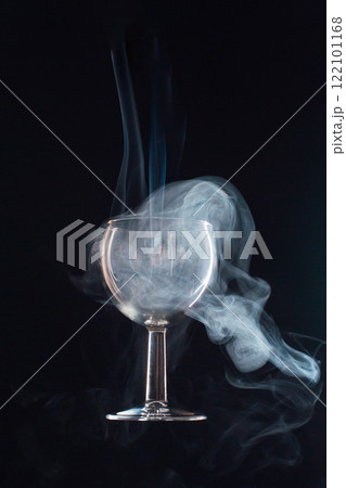 levitating glass full of smoke on a black background 122101168