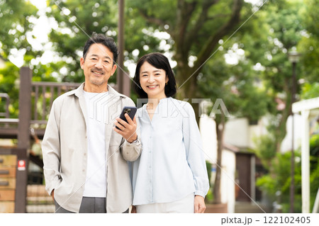 スマートフォンで調べものをするミドル夫婦 ライフスタイルイメージ	 スマートフォンで調べものをするミドル夫婦 ライフスタイルイメージ	 122102405