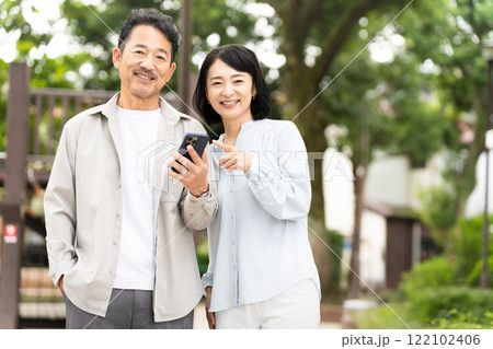 スマートフォンで調べものをするミドル夫婦 ライフスタイルイメージ	 スマートフォンで調べものをするミドル夫婦 ライフスタイルイメージ	 122102406