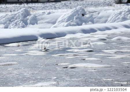 水の入った田んぼに雪が積もった様子 水の入った田んぼに雪が積もった様子 122103504