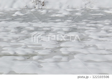 水の入った田んぼに積もった雪 122103506