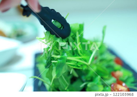 サラダを取り分ける女性の手元 122103968