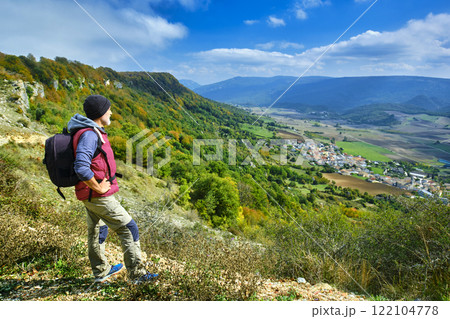 Hiker Admiring Scenic Landscape from a Mountain Viewpoint. Hiker Admiring Scenic Landscape from a Mountain Viewpoint. 122104778