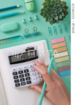 Financial planning with a calculator and mint green stationery. The word Profit in English on the calculator. 122106119
