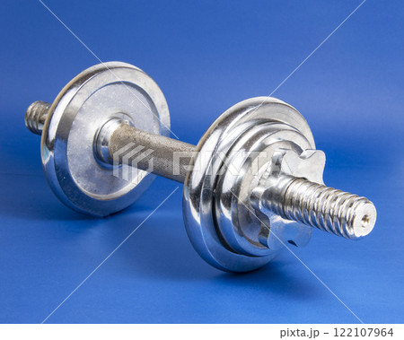 Stainless metal dumbbell on dark blue background with copyspace for text Stainless metal dumbbell on dark blue background with copyspace for text 122107964