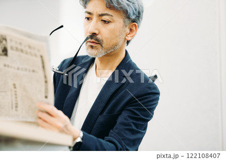 新聞を読むミドルの男性 122108407