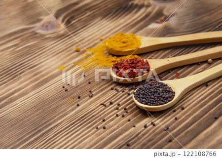Aroma wooden spoon with different dry spices on natural wooden background 122108766