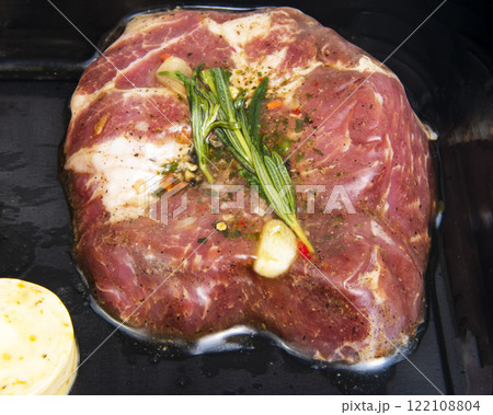 Fresh meat pork with garlic, rosemary in vacuum black pack 122108804