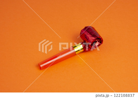 Party foil red horn noisemaker for carnival on the orange background Party foil red horn noisemaker for carnival on the orange background 122108837