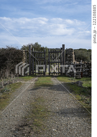 Rustic wooden gate with dry stone wall in a rural countryside 122108885