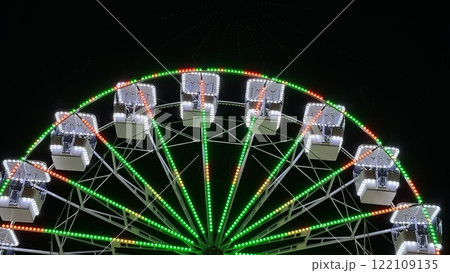 A brightly illuminated Ferris wheel against the night sky 122109135