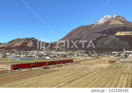 秋の由布岳と湯布院盆地を走る赤い列車 122109185