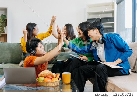 Happy group of college students use laptop feel excited overjoyed triumph with good news over smartphone or Tablet. 122109723