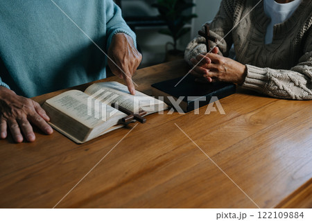 Men and women praying to God with the Bible, seeking blessings and guidance.  heartfelt depiction of faith, devotion, and spiritual connection. 122109884