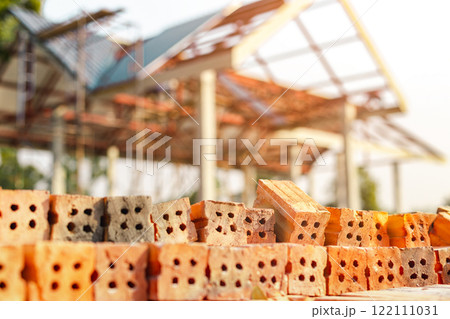 Red bricks stacked at a construction site, close-up. at the building site, red keramoblock hollow bricks Close up of the red brick used in the construction of the building's walls and partitions. 122111031