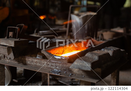 Mold with molten metal in the foundry workshop of metallurgical plant Mold with molten metal in the foundry workshop of metallurgical plant 122114304