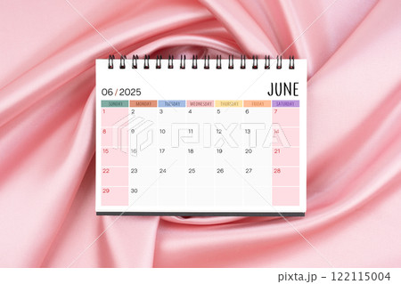 June 2025 desk calendar on pink color silk textile background, Flat lay. 122115004